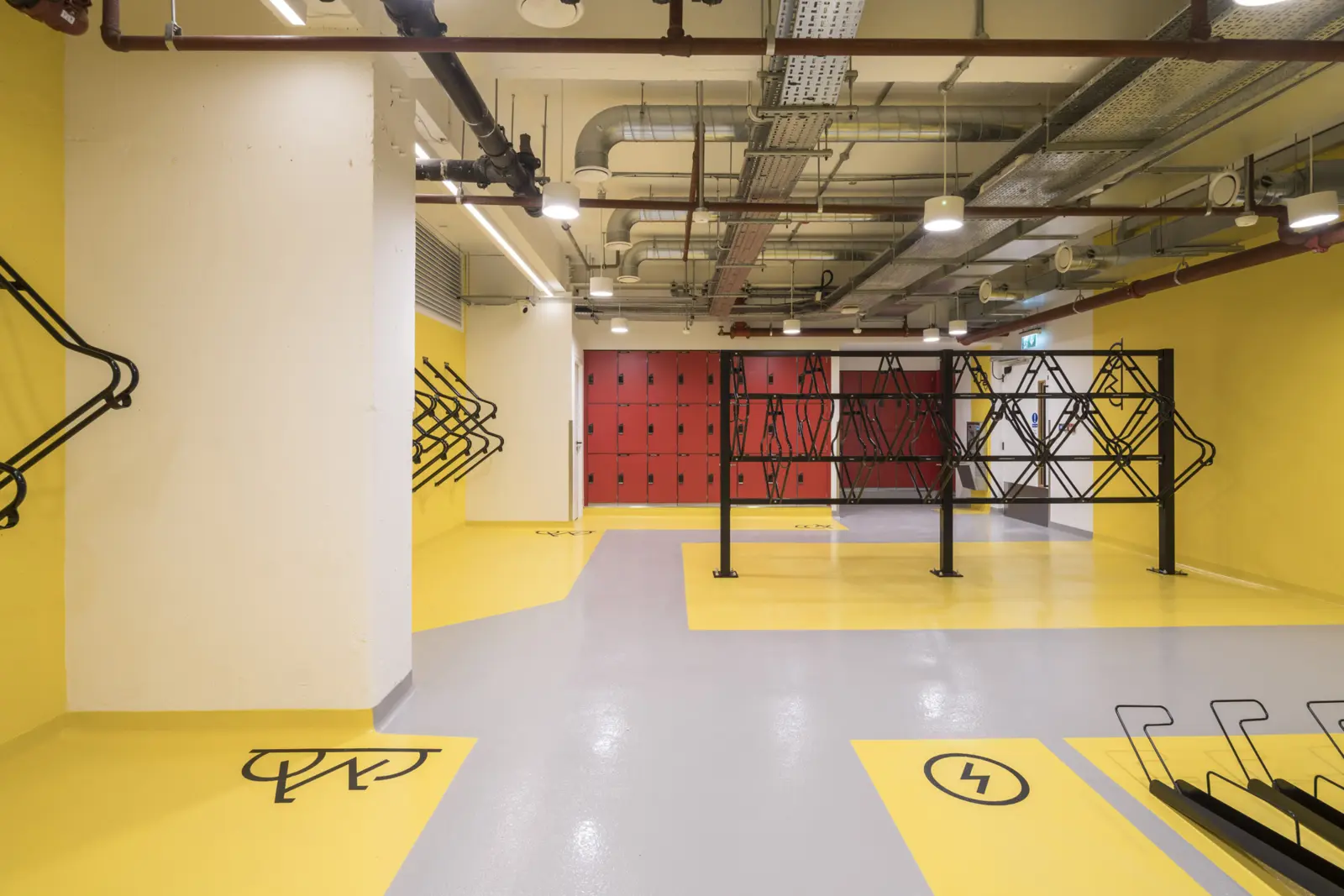 Resin floor coating with yellow line-marked bays in a commercial cycle store